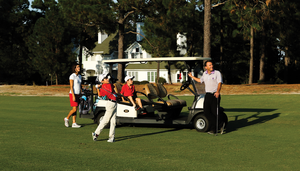 Cart on golf course wiht golfers
